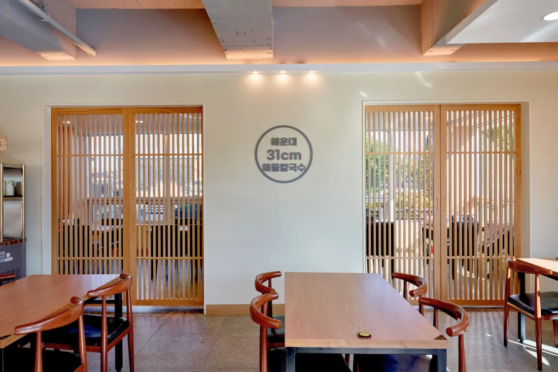 해운대31해물칼국수 울산동구점(울산 동구) 브랜드 사인을 붙인 벽과 나무 살 창호 — 음식점 인테리어 시공 사례